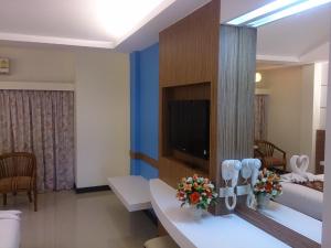 a hotel room with a television and a bed at The Camelot Hotel Pattaya in Pattaya South