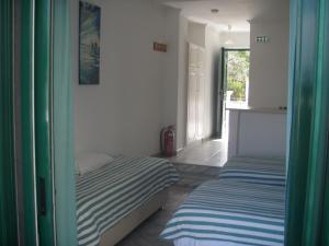 una camera con due letti e una porta con finestra di UMBRELLA BEACH APARTMENTs a Kávos