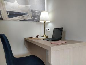 escritorio con ordenador portátil, lámpara y silla en Lilly Apartments, en Atenas