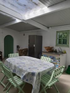 een keuken met een tafel met stoelen en een koelkast bij La Caillerie in Chauvé