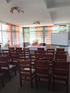 une salle de conférence avec des chaises et un écran blanc dans l'établissement Motel Prietenia, à Giurgiu