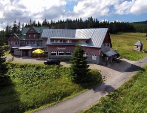 um grande celeiro vermelho com um carro estacionado em frente dele em Horská chata Sedmidolí em Spindleruv Mlyn