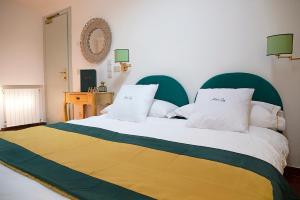 una camera da letto con un letto grande con testiera verde di Hotel Iva a Diano Marina Altre 44 foto