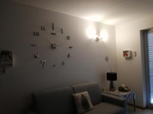 un soggiorno con divano e orologio sul muro di Cà delle Rose a Rovereto