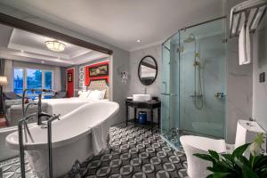 a bathroom with a tub, toilet, sink and shower at Acoustic Hotel & Spa in Hanoi