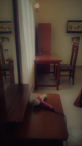 ein Zimmer mit einem Tisch und einem Stuhl und einer Bürste auf dem Boden in der Unterkunft Madara Hotel in Horana
