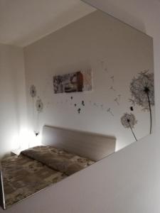 een slaapkamer met een bed en paardenbloemen aan de muur bij Cà delle Rose in Rovereto