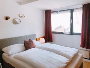 - une chambre avec un lit doté de draps blancs et une fenêtre dans l'établissement Gästehaus Ehebachhof Hotel Garni, à Müllheim