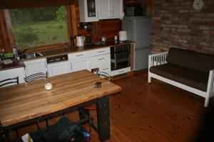 een keuken met een tafel en een bank in een kamer bij Jaunzemji in Dzeņi