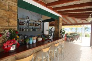 a bar in a restaurant with chairs and tables at UMBRELLA BEACH APARTMENTs in Kavos
