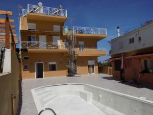 a building with a swimming pool in front of a building at Souvlakis Pool Suites (S.P.S) in Chania