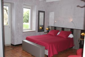 a bedroom with a large bed with a red blanket at les agnates in Flagey-Échézeaux