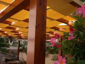 a wooden roof over a patio with pink flowers at Hotel Sirios in San Giovanni Rotondo