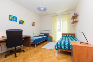 a bedroom with two beds and a desk and a computer at Comfort Premium Apartment in Poreč