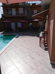 a patio with a pool and a table and chairs at Souvlakis Pool Suites (S.P.S) in Chania