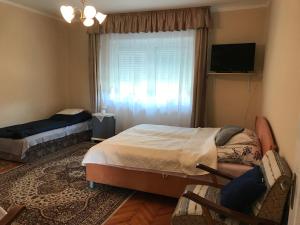 a bedroom with two beds and a window at Bandi Vendégház in Verpelét