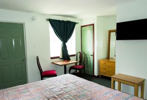 a bedroom with a bed and a desk and a window at Bay Drive Motel West Atlantic City in West Atlantic City