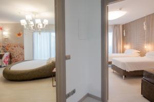 a bedroom with a bed and a tub in a room at Bibione Palace Spa Hotel in Bibione