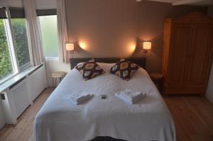 a bedroom with a white bed with two towels on it at Bed and Breakfast Hattem in Hattem