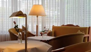 巴特歐波的住宿－萊茵蘭酒店，餐厅配有带台灯和椅子的桌子