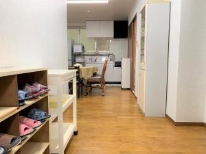 eine Küche mit weißen Schränken und einem Tisch im Zimmer in der Unterkunft “Okawa Stay” Five-Bedroom Condo in Ishigaki-jima