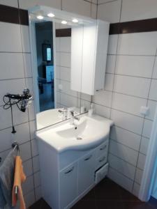 a bathroom with a white sink and a mirror at Studios Oleander in Limenaria