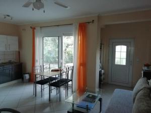 a living room with a table and chairs and an orange curtain at Studios Oleander in Limenaria