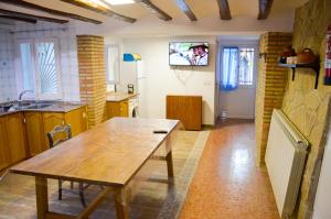 cocina con mesa de madera en una habitación en Casa Azafrán, en Torrijo del Campo
