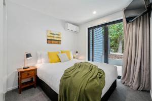 una camera con un letto e una grande finestra di Bright, Modern, Plush - Brand New Townhouse a Queenstown