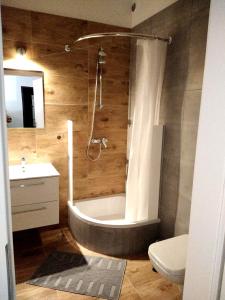 uma casa de banho com uma banheira, um WC e um lavatório. em Apartament Be Happy Nr 1 em Gdynia