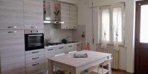 Casa Vacanze Terracina في Hermada: مطبخ أبيض مع طاولة وموقد