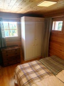 a bedroom with a bed and two windows at Metsorinne in Kotila