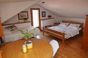 Un dormitorio con 2 camas y una mesa con una maceta. en Studios Jacobus, en Korčula