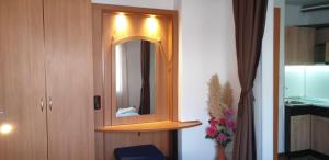 a bathroom with a mirror and a wooden cabinet at Primorsko Apartments in Primorsko +78 photos