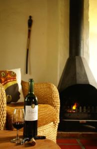 una bottiglia di vino seduta su un tavolo con un bicchiere di Mooi Bly a Paarl