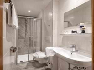 a bathroom with a toilet and a sink and a shower at Hotel Alpenhof in Bad Hofgastein