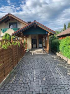 a house with a fence and a brick driveway at Casa al Lago in Faak am See