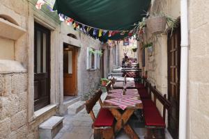 una calle en un callejón con mesas y banderas en Studios Jacobus, en Korčula