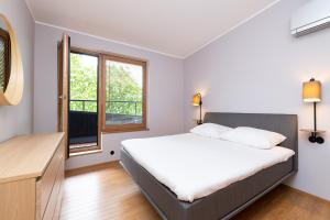 1 dormitorio con cama y ventana en Self-check-in 3 bedroom apartment with sauna and balconies en Tallin