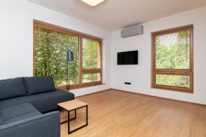 a living room with a blue couch and two windows at Self-check-in 3 bedroom apartment with sauna and balconies in Tallinn
