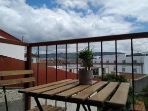 a wooden bench sitting on top of a balcony at Anjo33 Flats in Braga