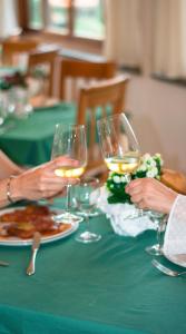 un groupe de personnes assises à une table avec des verres à vin dans l'établissement Guardia dei Mori, à Carloforte