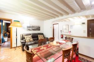 Ca' del Carro Family Apartment في البندقية: غرفة معيشة مع طاولة وأريكة