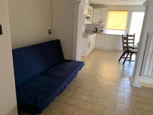 uma sala de estar com um sofá azul e uma cozinha em Family room for 4-6 person em Budapeste