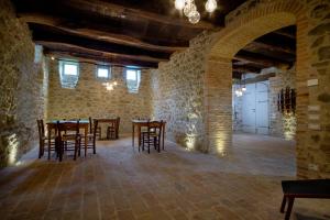 un comedor con mesas y sillas en un edificio de piedra en Palazzo Serre - Natura & Piscina, en San Leo