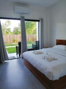 a bedroom with a bed and a large window at Christelle Inn in Panglao