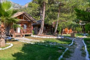 a log cabin with a path leading to a house at Sea Valley Lodge in Faralya