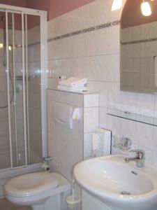 a bathroom with a sink and a toilet and a shower at Hotel Zur Linde in Meldorf