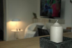 una vela sentada en una mesa en una sala de estar en Bakkely GuestHouse, en Randers