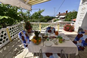 uma mesa com comida e fruta numa varanda em Guest house Tom em Malinska
